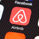A cell phone screen displaying the logo for Airbnb